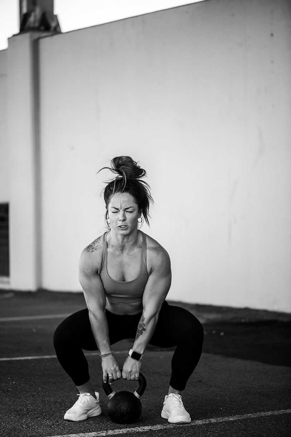 Ashley holding a kettlebell, black and white